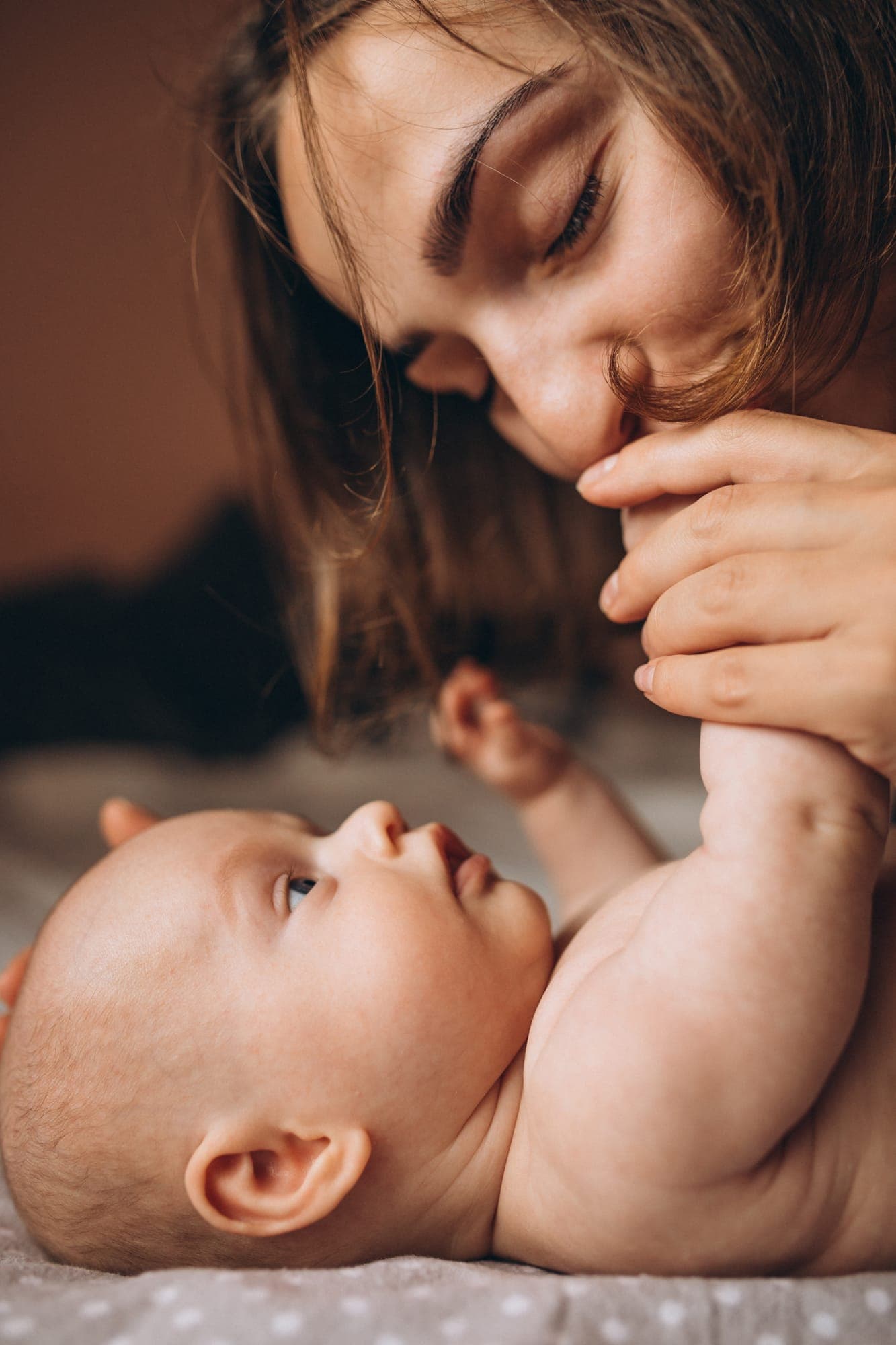 Rituels maman & bébé à domicile Maman et son nouveau-né partageant un instant de tendresse pendant un rituel